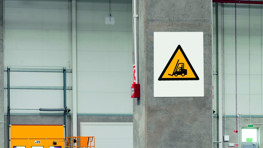 Betonový sloup v průmyslové hale s výstražnou značkou vysokozdvižný vozík