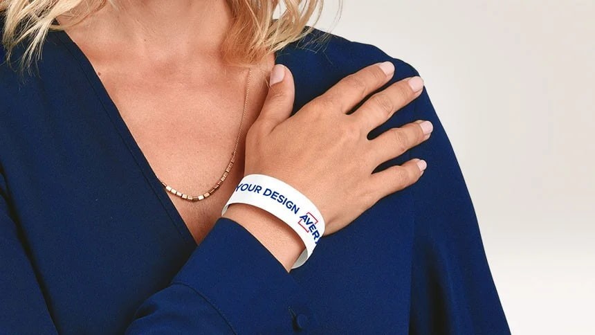 Identifikační pásek s logem Avery na zápěstí ženy