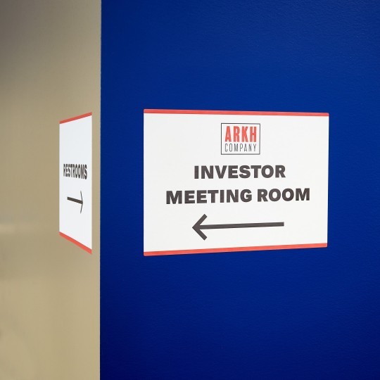 Velká cedule na stěně s nápisem: Investor meeting room a se šipkou