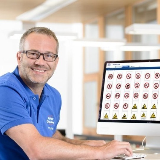 Muž sedící u monitoru používající software design & print