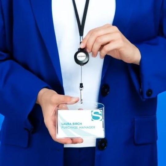 Muž v modrém obleku se šňůrkou se jmenovkou na krku