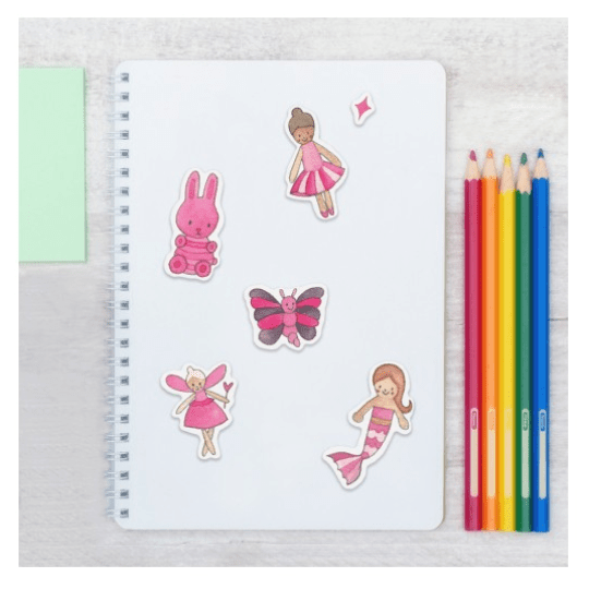 Pořadač s pěti růžovými samolepkami víl, motýla, mořské panny a králíka. Vedle něj je naskládáno několik pastelek.