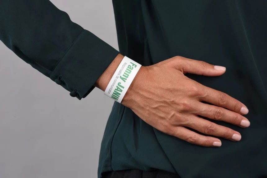 Ruka na tmavé látce se světlou páskou na zápěstí