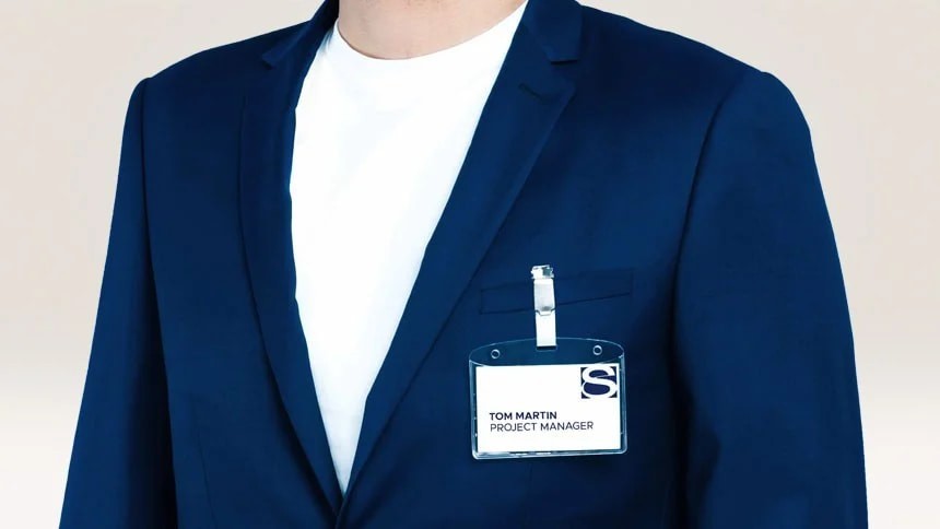 Muž v bundě s připevněnou jmenovkou v držáku