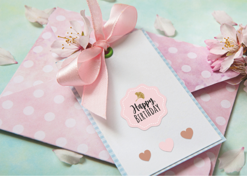 Bílá taška s růžovou nálepkou a růžovou stuhou