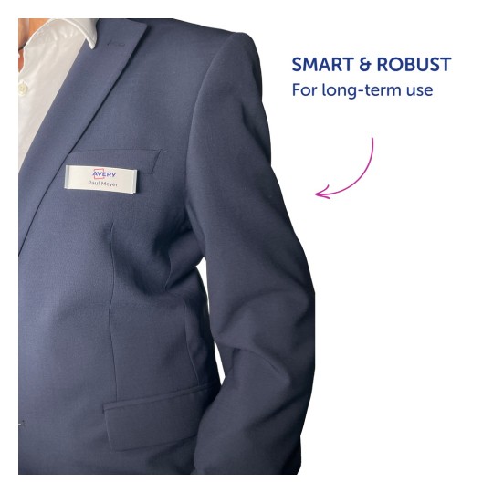 Obrázek zobrazuje detail trupu osoby, která má na sobě tmavé sako. Na saku je připevněna jmenovka s nápisem 'Paul Meyer' a nedaleko je text 'CHYTRÉ & ODOLNÉ Pro dlouhodobé použití.'