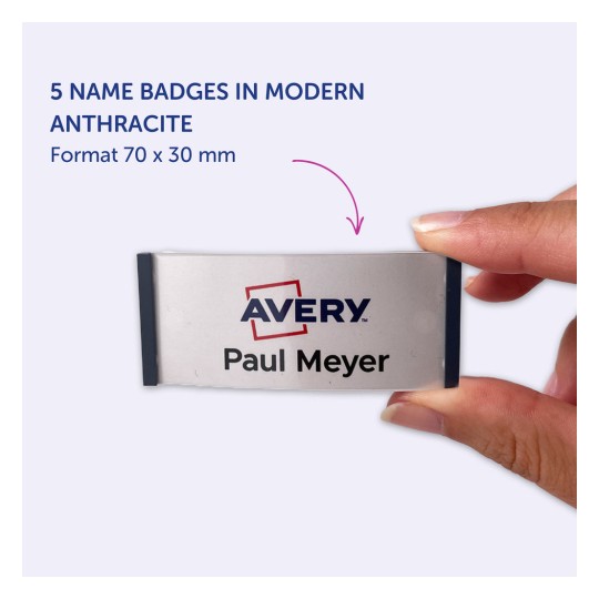 Obrázek ukazuje osobu držící jmenovku s nápisem 'Avery Paul Meyer', která zobrazuje pět jmenovek v moderní antracitové barvě o rozměrech 70 x 30 mm.