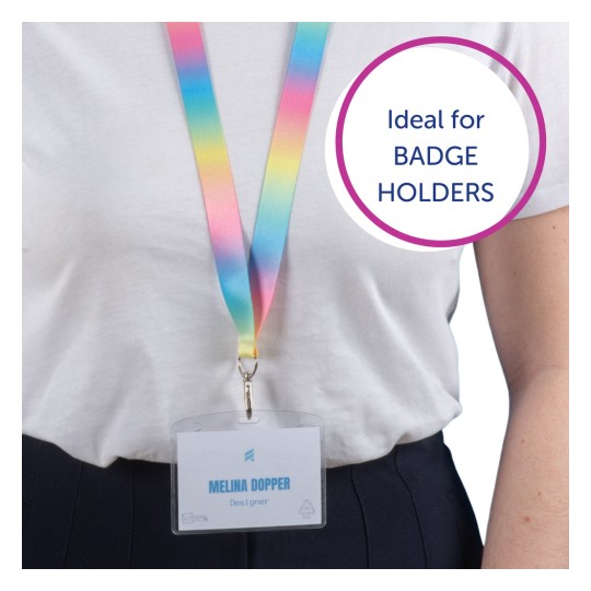 Obrázek zobrazuje osobu nosící barevnou šňůrku s odznakem, který nese nápis 'Melina Dopper, Designér'. Šňůrka přechází z růžové na žlutou a do modré a je zde textová bublina se zněním 'Ideální pro DRŽÁKY NA ODZNAKY'.