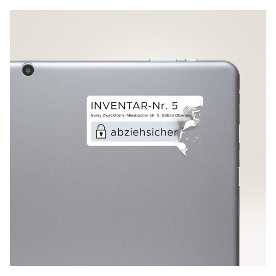 Obrázek zobrazuje zadní stranu zařízení s štítkem, na kterém je napsáno 'INVENTAR-Nr. 5' a obsahuje adresu. Štítek se zdá být částečně roztržený nebo odlepený.