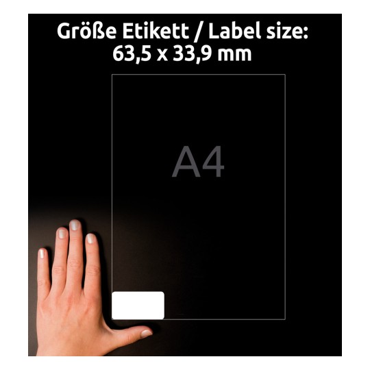 Obrázek zobrazuje ruku vedle etikety o velikosti 63,5 x 33,9 mm, s výrazně zobrazeným písmenem 'A4'. Pozadí je tmavé, což zdůrazňuje velikost etikety a ruku.