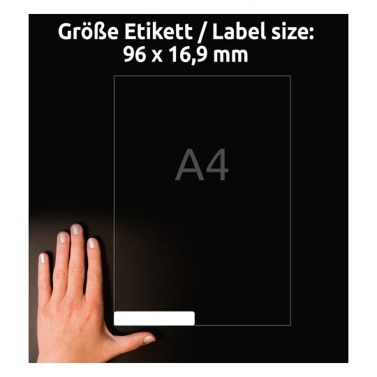 Obrázek zobrazuje ruku vedle grafiky štítku s rozměry 96 x 16,9 mm. Štítek je umístěn ve vztahu k listu formátu A4 a je prezentován na tmavém pozadí.