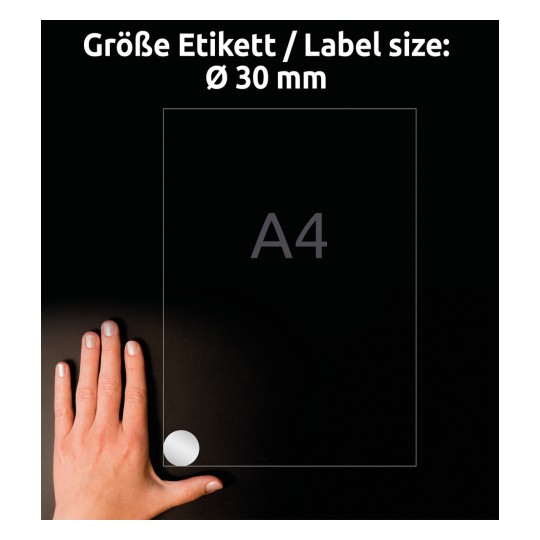 Obrázek zobrazuje ruku umístěnou na tmavém povrchu vedle listu A4 označeného kruhovým štítkem o velikosti 30 mm.