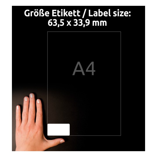 Obrázek ukazuje štítek o rozměrech 63,5 x 33,9 mm, s uvedenou velikostí papíru A4 a rukou pro měřítko.