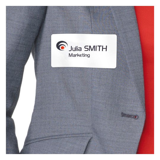 Obrázek ukazuje osobu oblečenou v šedém saku s visačkou se jménem 'Julia SMITH Marketing', která je k němu připevněná.