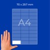 Ruka vedle modrého mřížkovaného listu A4 označeného 70 × 29,7 mm?