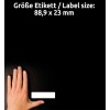 Obrázek zobrazuje ruku vedle prázdného štítku na černém pozadí. Rozměry štítku jsou uvedeny jako 88,9 x 23 mm.