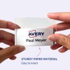Obrázek ukazuje osobu, která drží jmenovku s logem Avery a jménem 'Paul Meyer'. Jmenovku je zřejmě snadné vložit do držáku vyrobeného z pevného papírového materiálu.