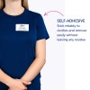 Obrázek zobrazuje osobu v námořnicky modré košili s jmenovkou, na které je napsáno 'B. Carlos, ŘEDITEL MARKETINGU.' Jmenovka je samolepicí a je zde text vysvětlující její vlastnosti.