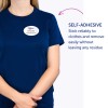 Obrázek zobrazuje osobu v modré košili s samolepicím jmenovkou, na které je napsáno 'B. Carlos, Marketingový ředitel.' Text zdůrazňuje lepicí vlastnosti jmenovky, což naznačuje, že pevně drží a lze ji odstranit bez zanechání zbytku.
