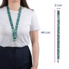 Obrázek ženy, která má na krku vzorovaný popruh na krk. Popruh má květinový design a je 44 cm dlouhý a 2 cm široký.