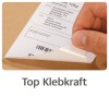 Obrázek ukazuje ruku, jak odlepuje štítek z kartonového balíku, s viditelnou doručovací adresou vedle čárového kódu. Pod obrázkem je zobrazen text "Top Klebkraft", což naznačuje silnou přilnavost.