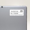 Obrázek zobrazuje zadní stranu tabletu nebo notebooku s etiketou. Na etiketě je napsáno 'INVENTAR Nr. 123456', což označuje inventární informace, a obsahuje značku 'Avery Zweckform' spolu s adresou.