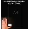 Obrázek zobrazuje ruku vedle štítku formátu A4 s rozměry 45,7 x 21,2 mm. Pozadí je tmavé, což zvyšuje viditelnost štítku a ruky.