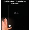 Obrázek zobrazuje ruku umístěnou na tmavém povrchu vedle listu A4 označeného kruhovým štítkem o velikosti 30 mm.